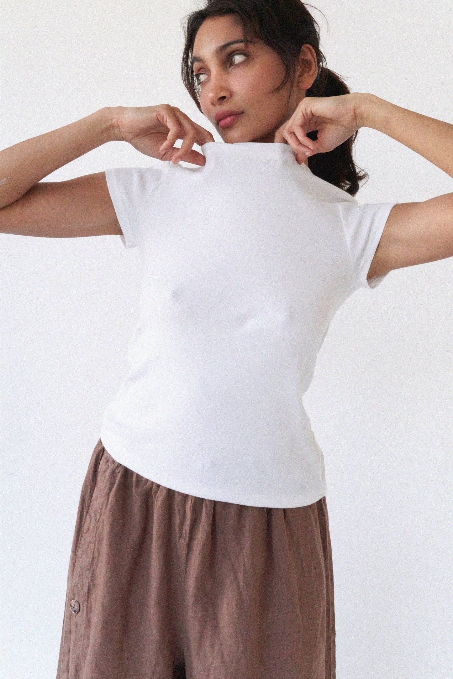 Model wearing the Bebe Organic Teen Tee in White with a soft fitted silhouette and cap sleeves.