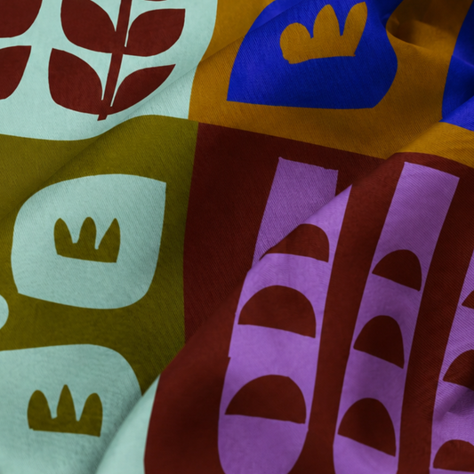 Close-up of the Botanical Colorblock silk scarf showing its colorful botanical pattern, lightweight fabric, and soft drape.