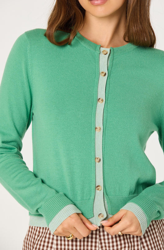 Close-up of the Clovis Color Block Faux Layered Cardigan showing the faux layered contrast placket, buttons, and double ribbed cuffs and hem.