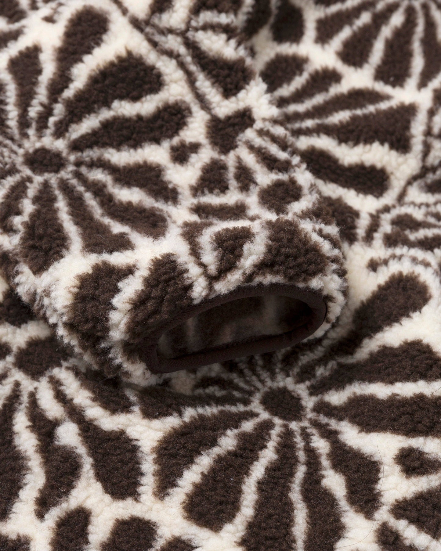 Close-up of the High Desert Wildflowers fleece showing the lined front pocket and brown and natural floral pattern.