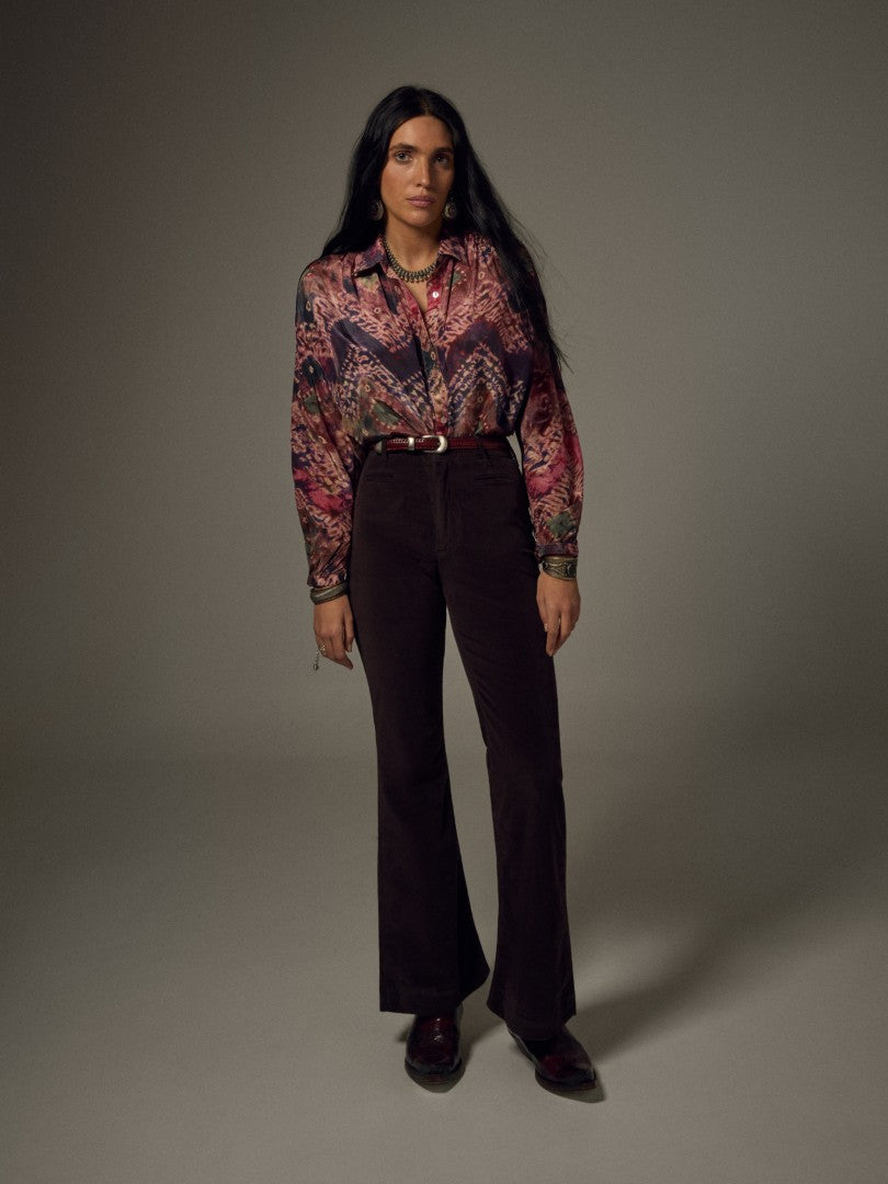 Model wearing the Maison Hotel Janis Shirt in Ayahuasca styled with dark high-waisted trousers and a belt.