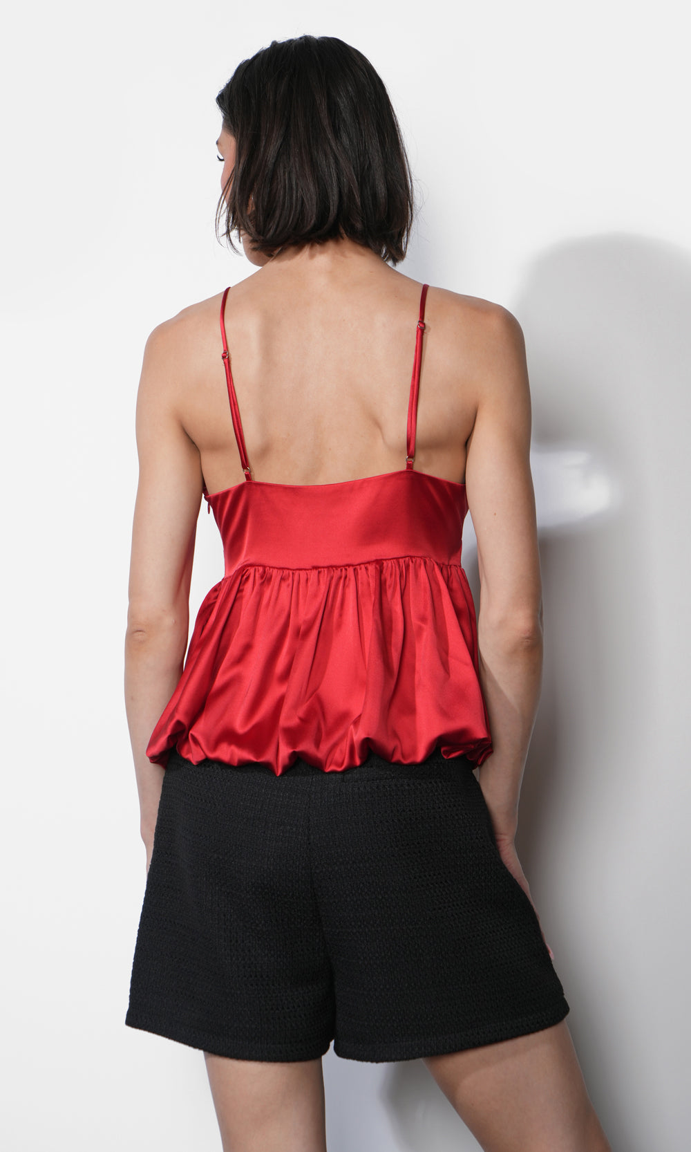 Back view of the Julia Bubble Hem Babydoll Cami with adjustable spaghetti straps, gathered bubble hem detail, and satin-like red fabric.