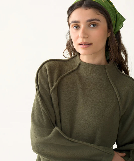 Close-up of model wearing the olive Mock Neck Pile Fleece showing the mock neckline, soft fleece texture, and raglan sleeves.