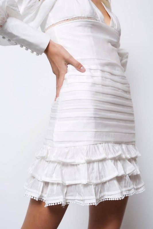 Full-length front view of the Monterey Plunge Neck Long Sleeve Mini Dress in white with a deep V-neckline, fitted waist, long sleeves, and cascading tiered ruffle hem.