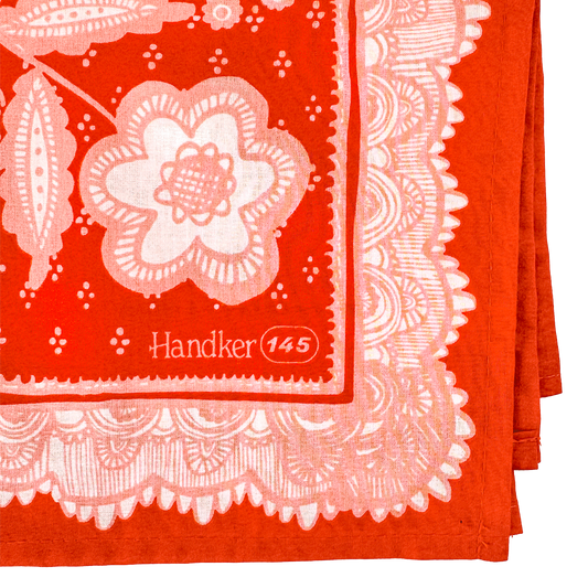 Folded Lacey Bandana showing the pink floral design, ornamental border, and printed corner detail.