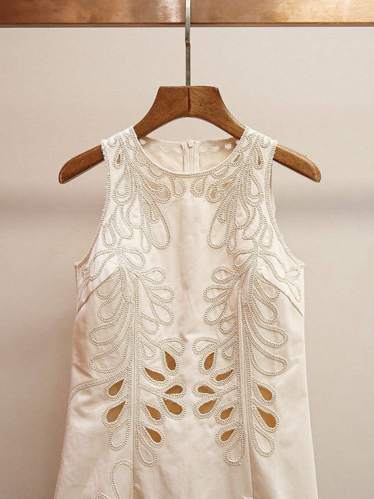 Close-up front view of the ProductSeeker ivory sleeveless dress highlighting the high neckline and ornate embroidered cutout detailing.