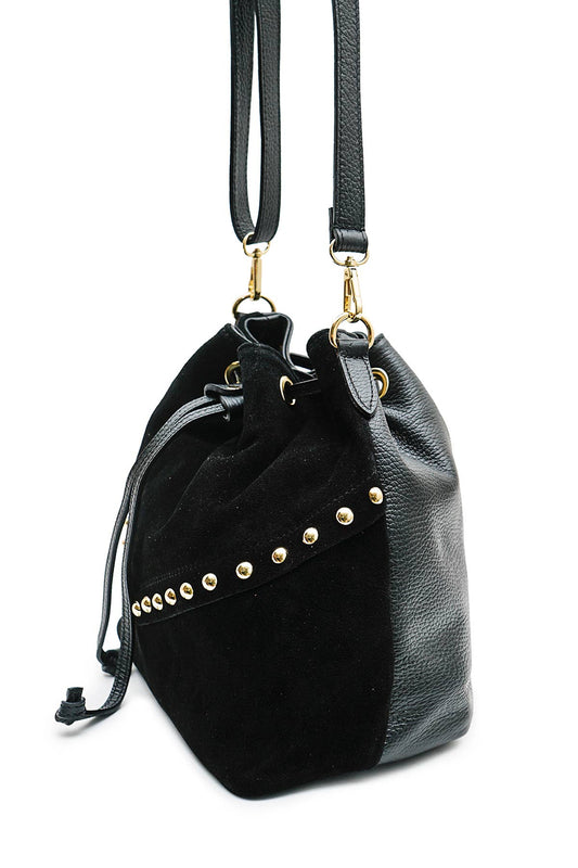Side view of the Régine Suede Bag in black suede, showing the structured base, stud detailing, and leather strap attachments.