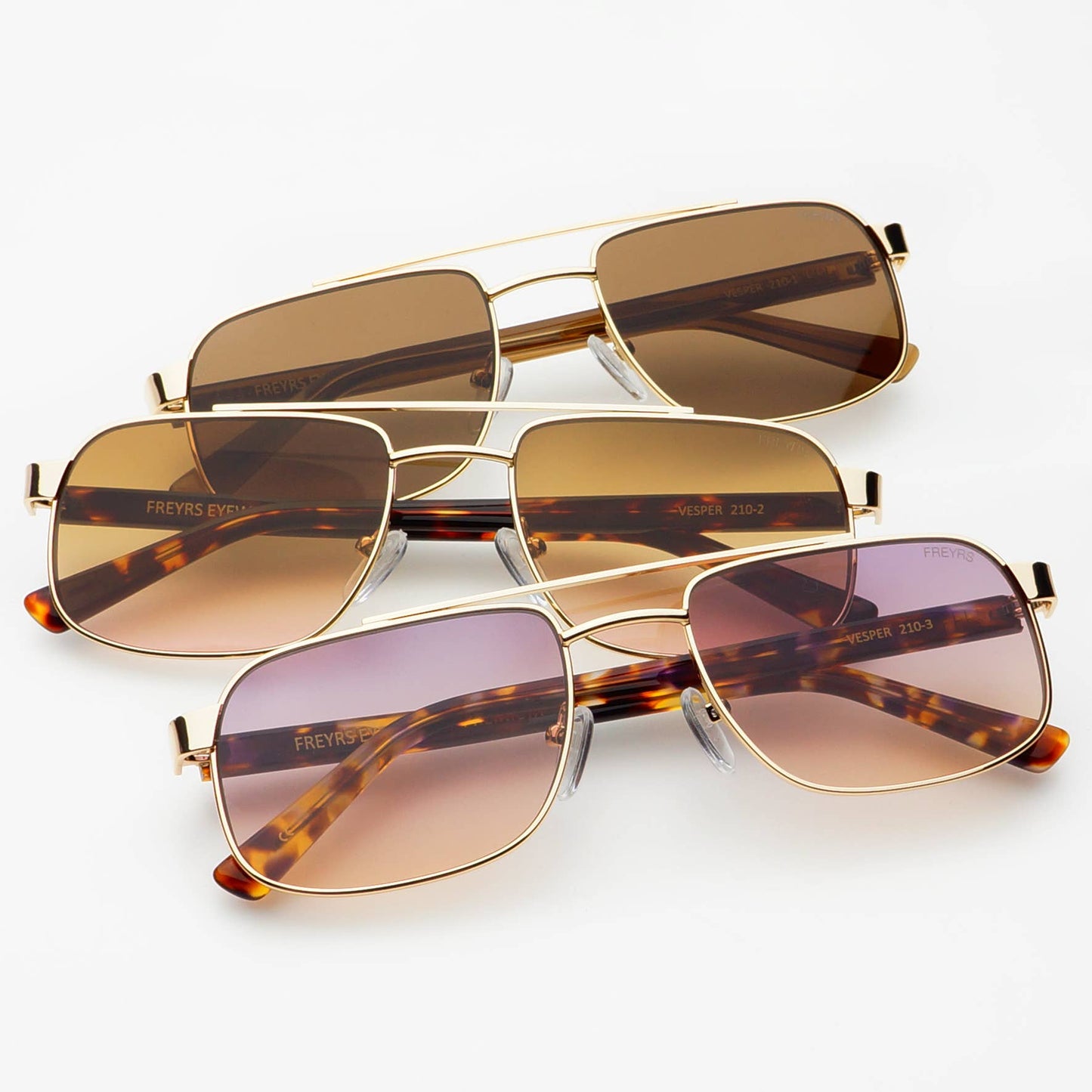 Three Vesper sunglasses colorways featuring gold-tone metal frames with brown, amber, and rose-tinted lenses displayed together.