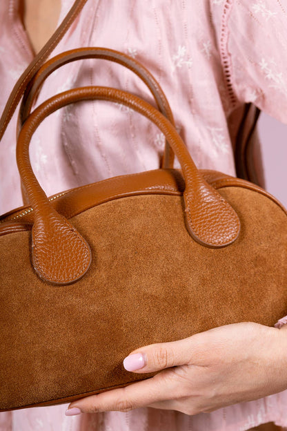 Close-up of the brown ARIELLE suede bag showing its curved leather handles and suede texture