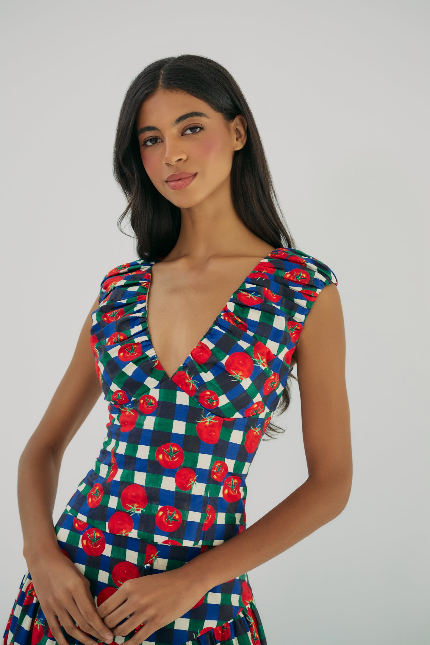 Close-up of Aiko V-neck top in gingham tomato print with gathered cap sleeves and fitted bodice