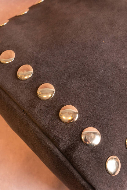 Close-up of polished gold studs along the chocolate brown suede Alexane Bag.