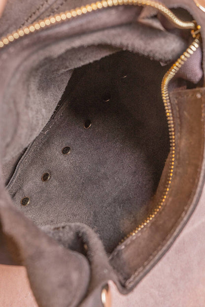 Interior of the chocolate suede Alexane Bag with a gold zip-top closure.