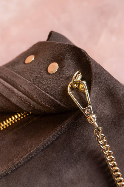 Close-up of the Alexane Bag’s gold clasp, chain strap, and chocolate suede finish.