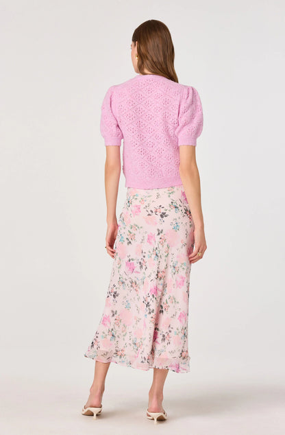 Model wearing the Ananda Floral Bias-Cut Ruffle Midi Skirt from the back, showing the blush floral print, lined midi shape, and fluid drape.