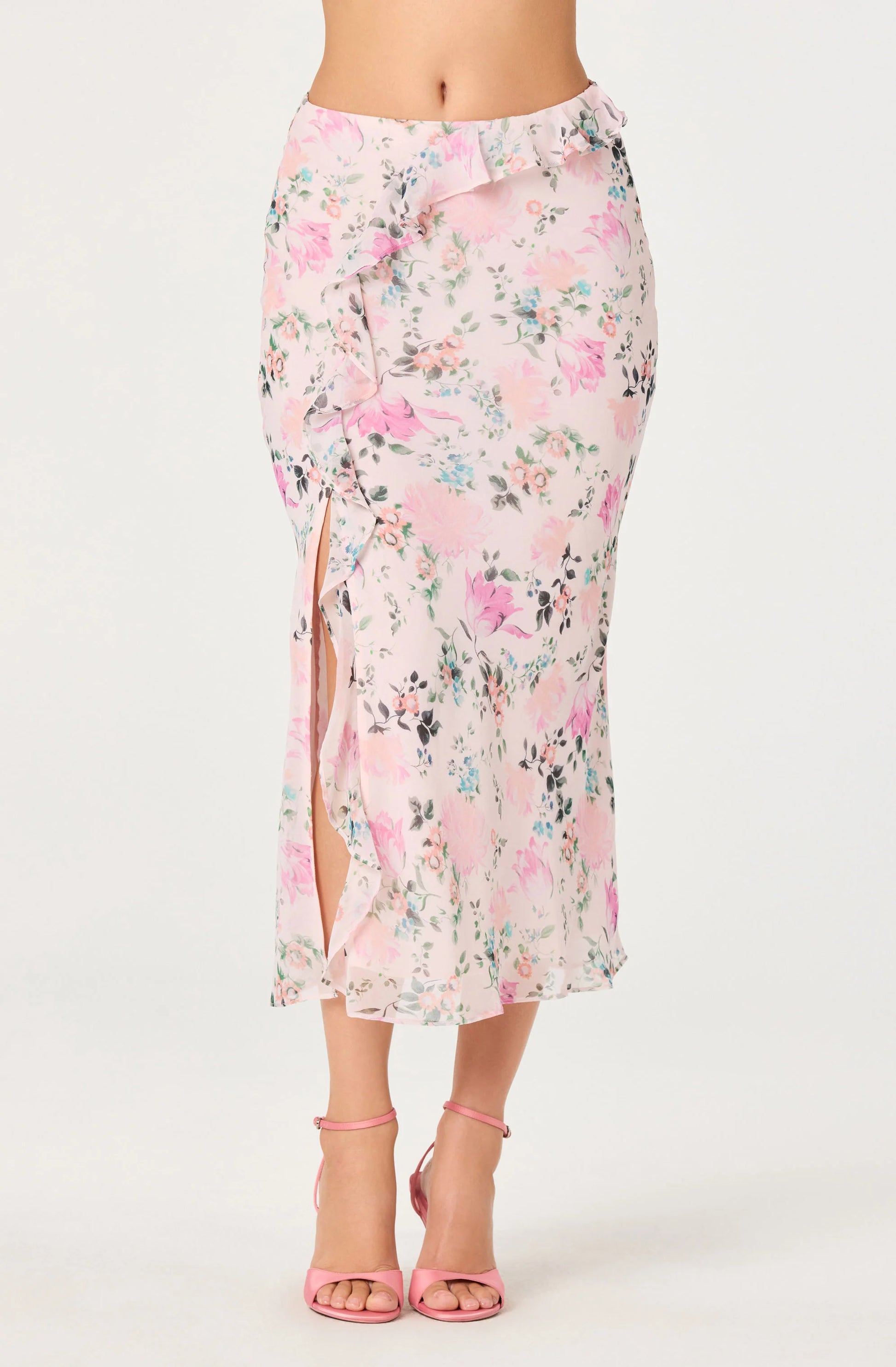 Close-up of the Ananda Floral Bias-Cut Ruffle Midi Skirt showing the asymmetric ruffle, blush floral chiffon, and front side slit.