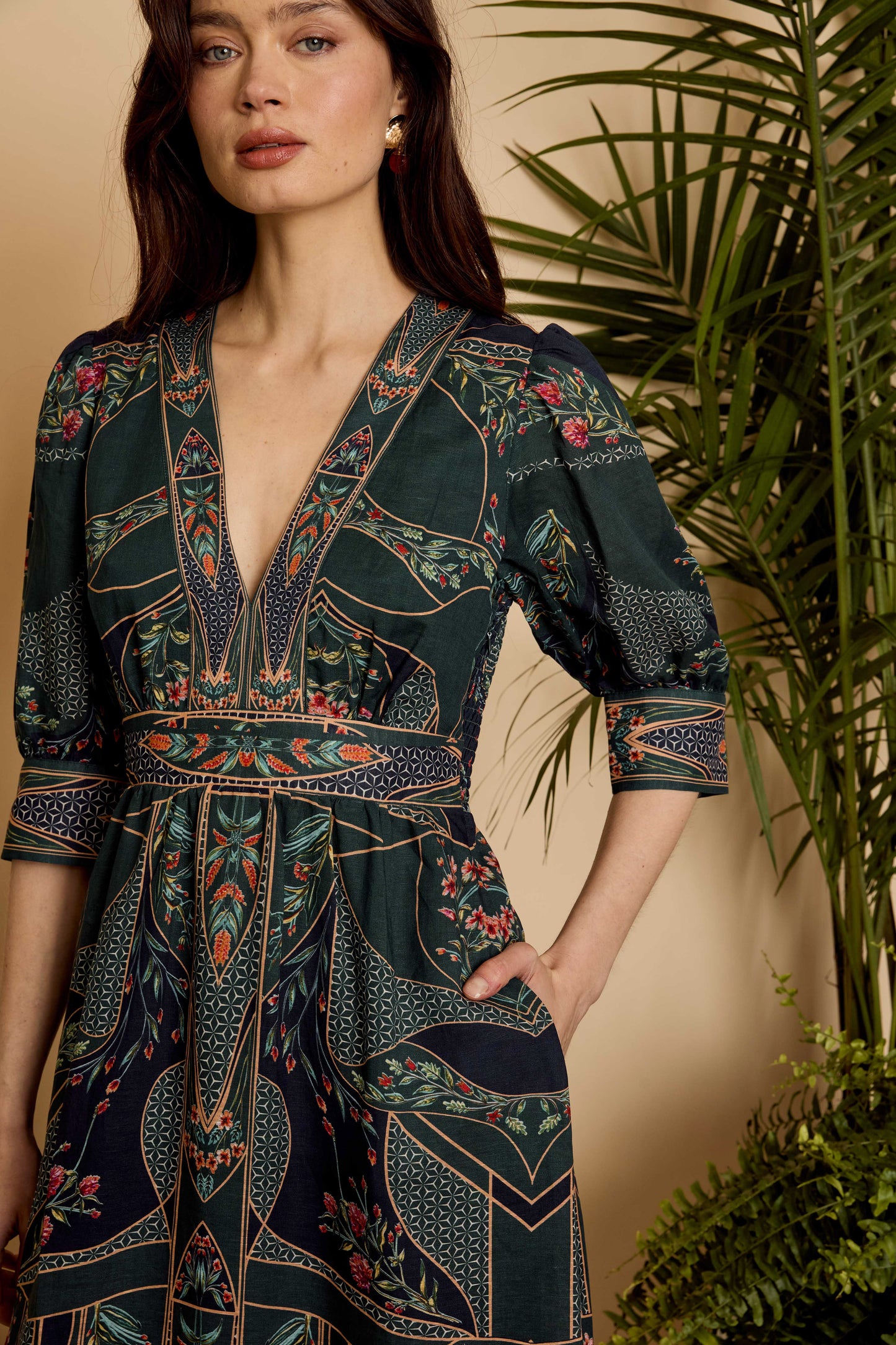 Close-up of the Aneta Dress in Patchwork Flower showing the deep V-neckline, defined waist, and three-quarter sleeves
