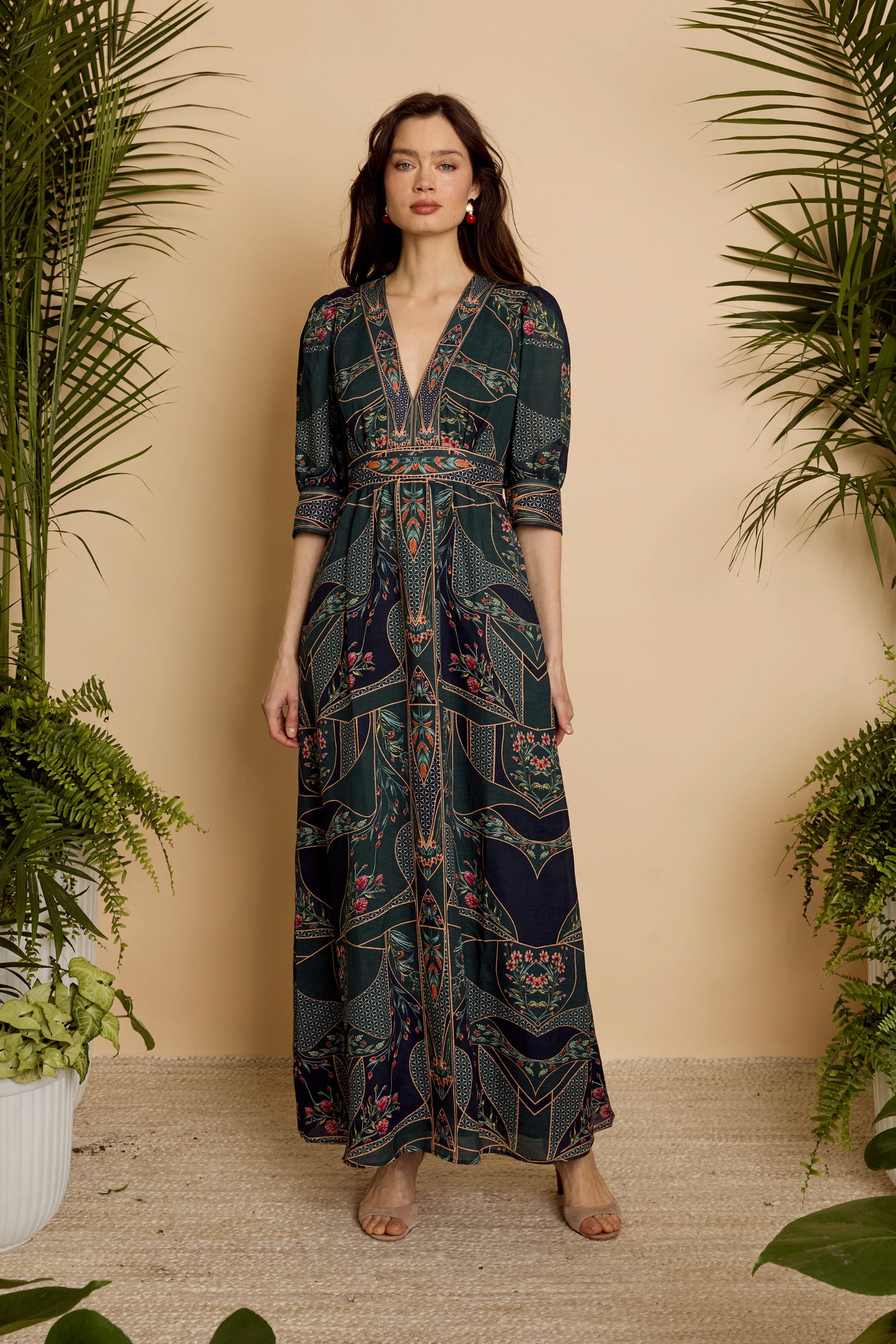 Front full-length view of model wearing the Aneta Dress in Patchwork Flower with deep V-neckline and flowing maxi skirt