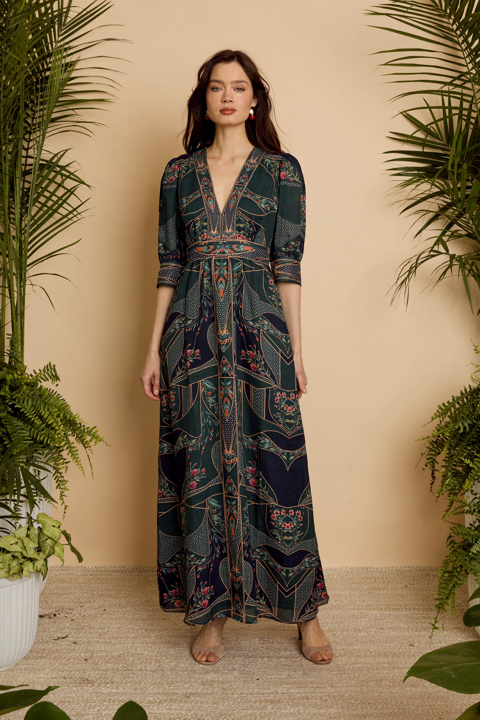 Front full-length view of model wearing the Aneta Dress in Patchwork Flower with deep V-neckline and flowing maxi skirt