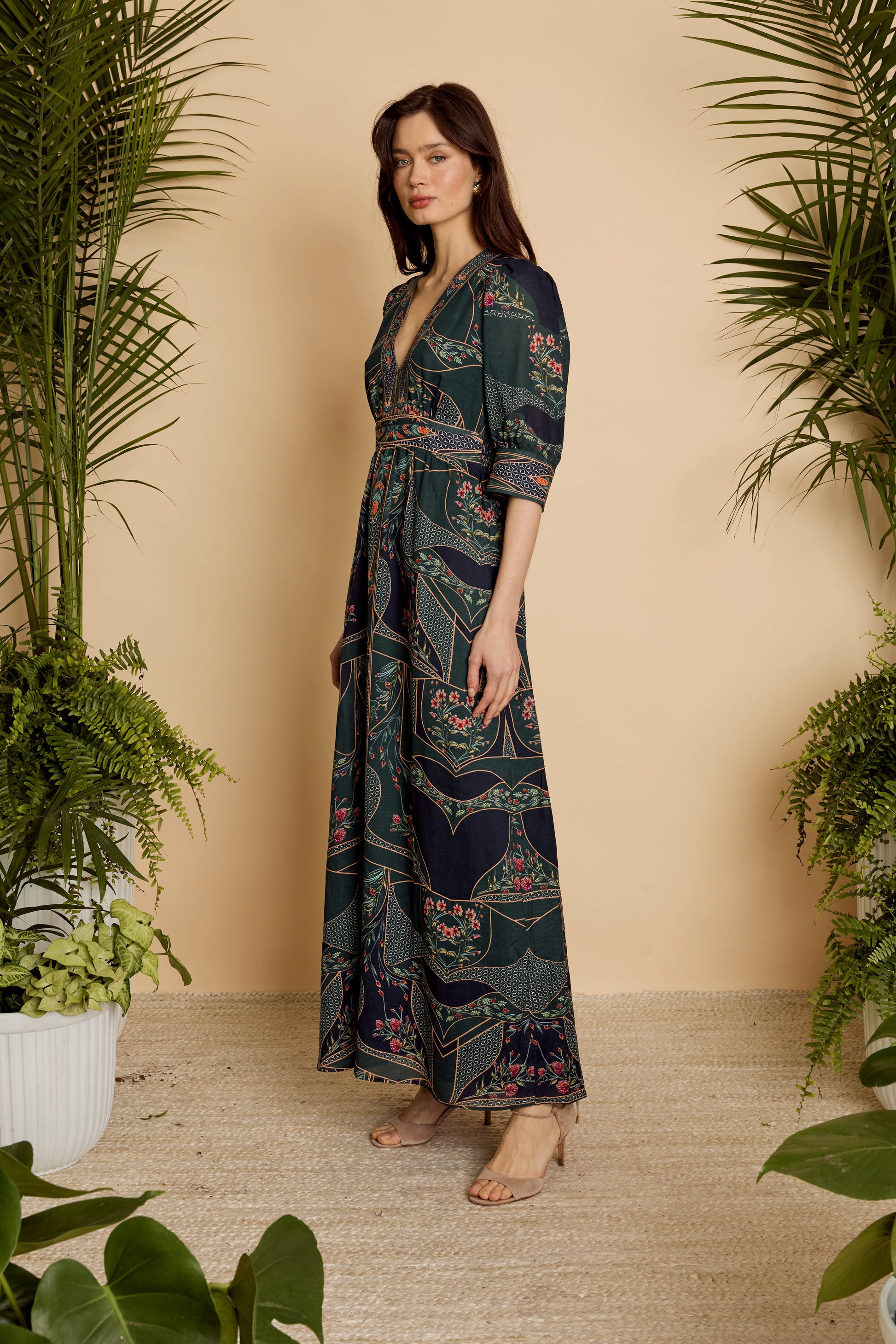Side view of model wearing the Aneta Dress in Patchwork Flower showing the draped silhouette and full-length skirt