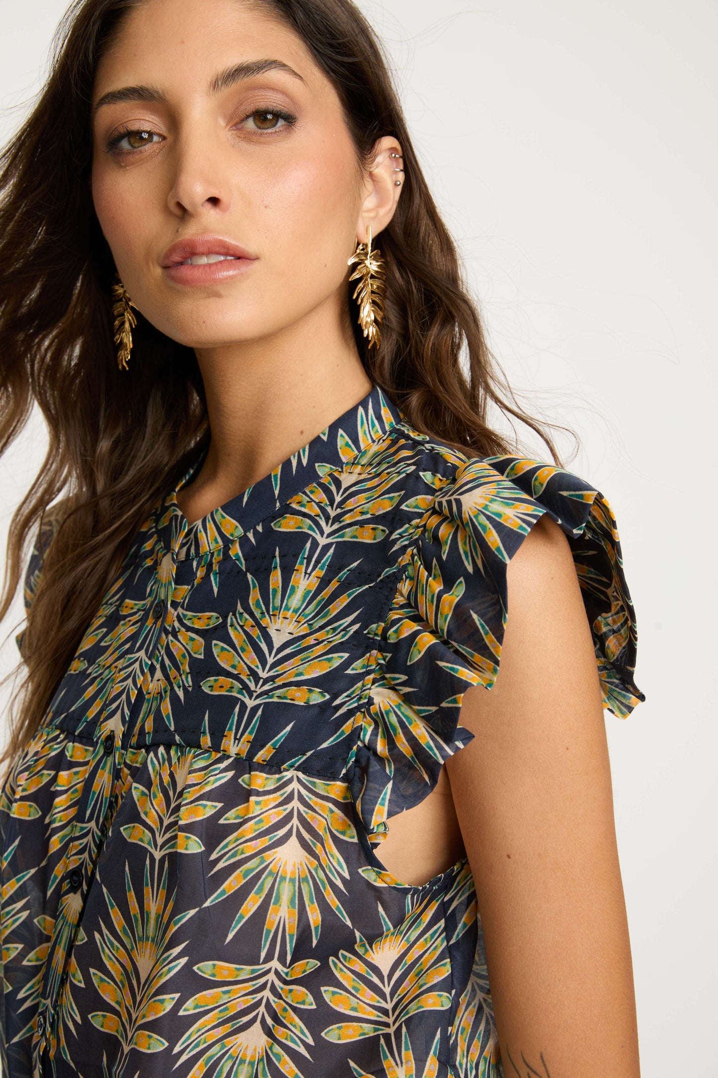 Close-up detail of the Anthea Top in Deco Plume highlighting the flutter sleeves, collared neckline, and yellow tropical leaf print on dark blue fabric.