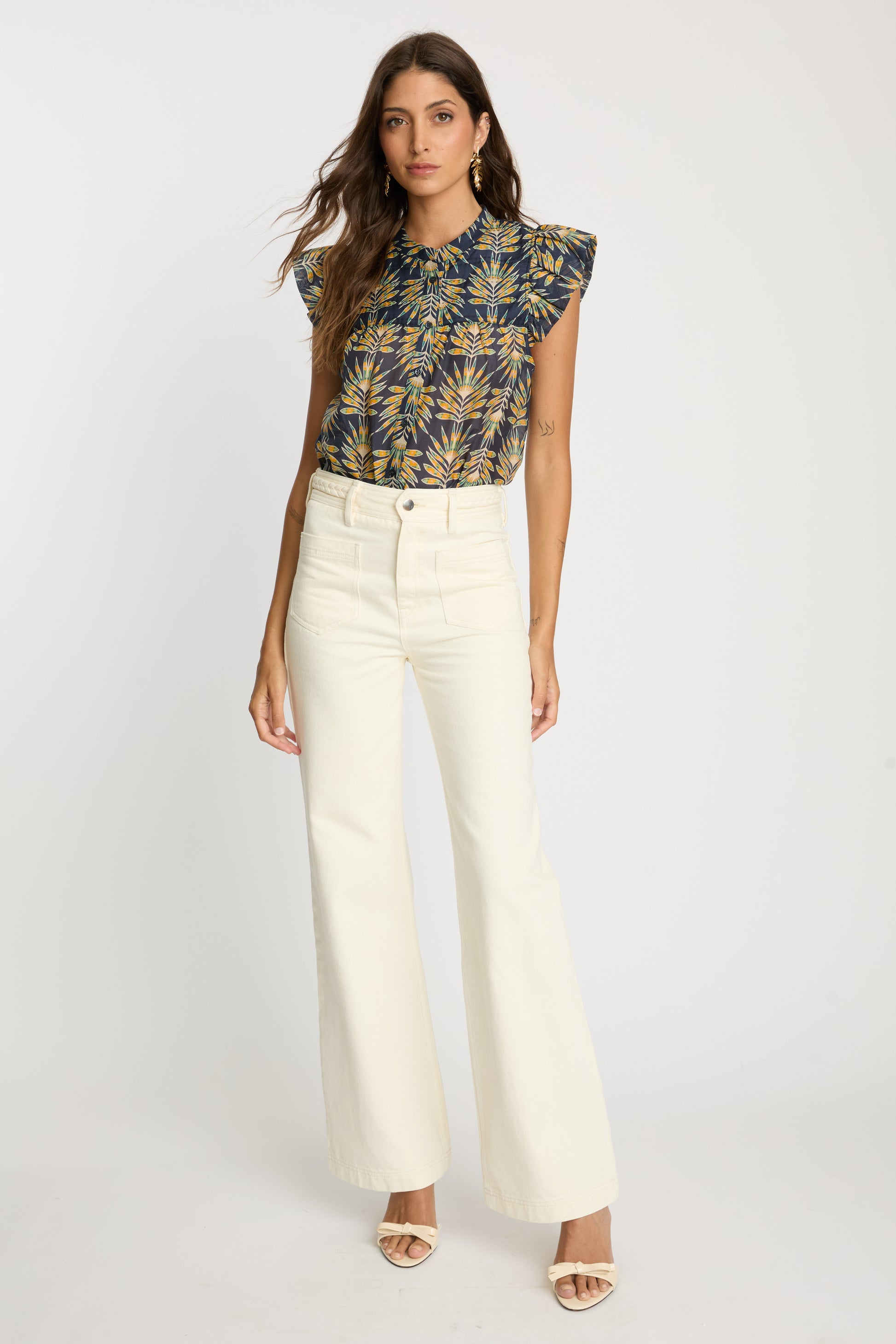 Full-length view of the Anthea Top in Deco Plume paired with cream wide-leg pants, featuring a yellow tropical leaf print and flutter sleeves.