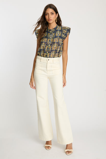 Full-length view of the Anthea Top in Deco Plume paired with cream wide-leg pants, featuring a yellow tropical leaf print and flutter sleeves.