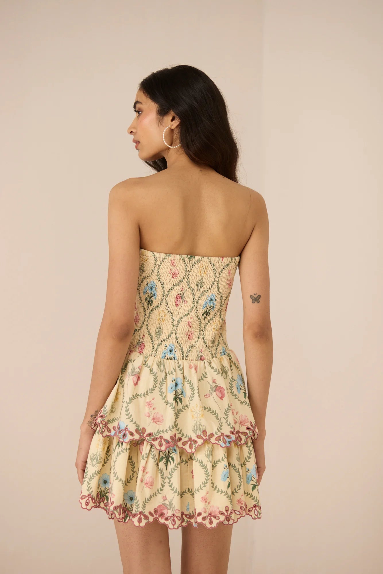 Back view of the Apricot Mini Dress showing the strapless smocked bodice and flowy mini skirt.