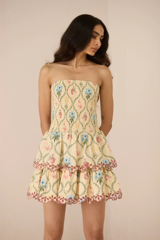 Close front view of the Apricot Mini Dress showing the strapless smocked bodice and delicate Blue Meadow print.
