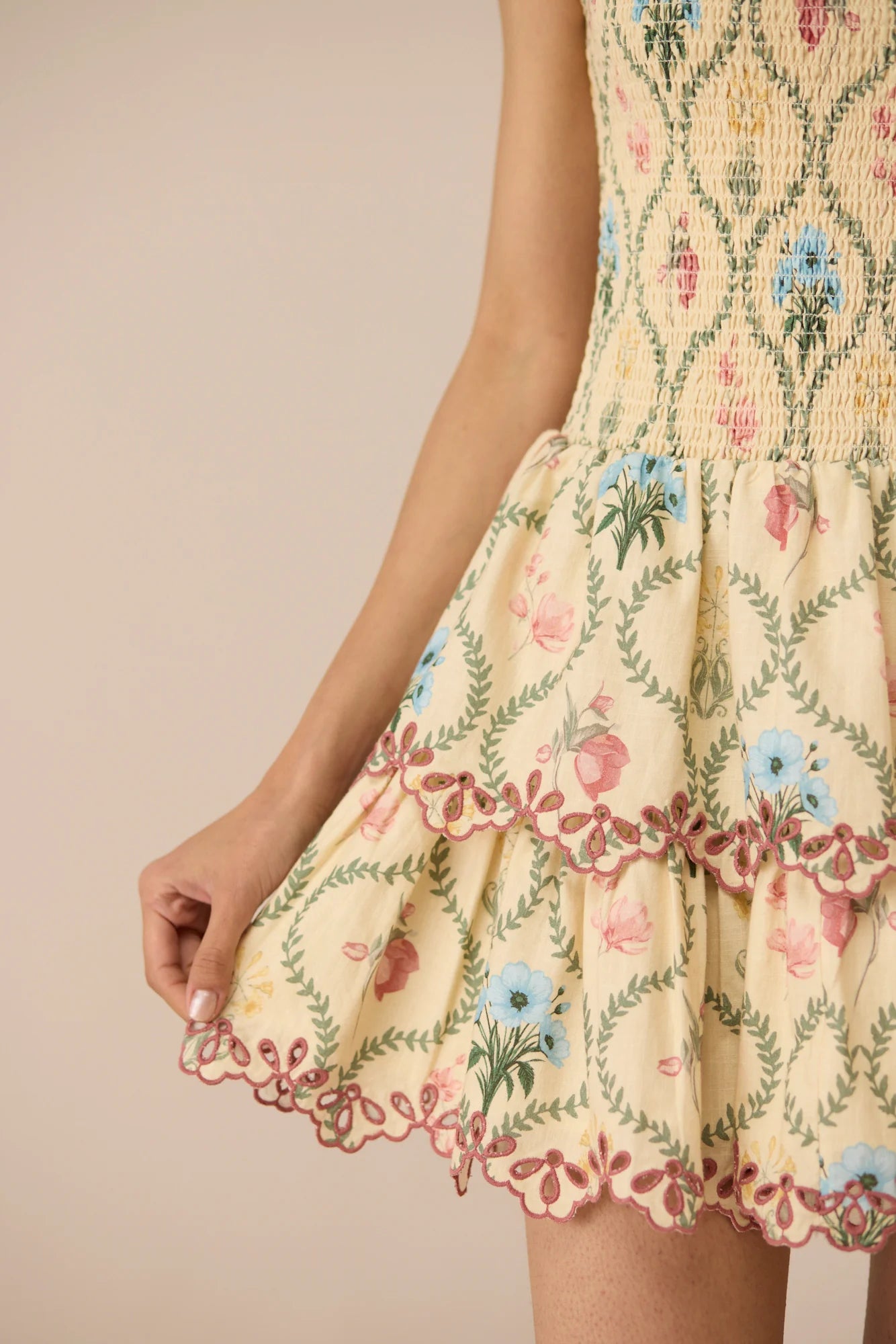 Close-up detail of the Apricot Mini Dress showing the printed cotton fabric and tiered skirt.