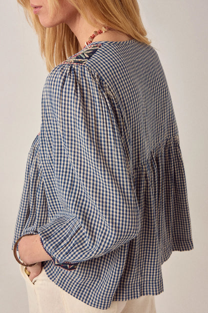 Back detail of the April Blouse in Bleu Picnic showing gathered construction, flowing silhouette, long sleeves, and blue and white gingham cotton fabric.