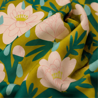 Close-up of the April Showers silk scarf with illustrated pink flowers, raindrops, and leafy green details.