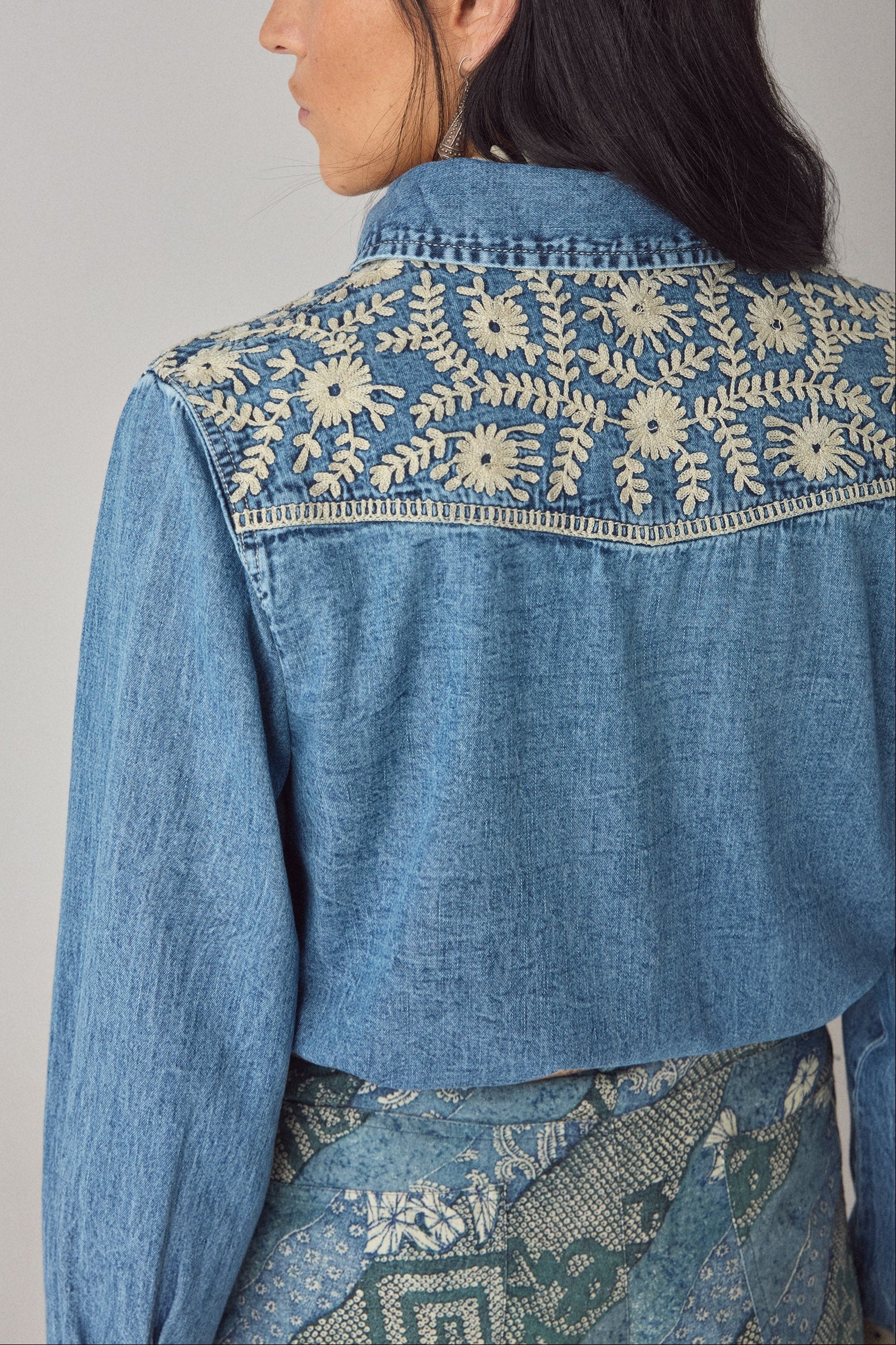 Back detail of the Arizona Thelma blue denim shirt showing intricate floral embroidery across the shoulders