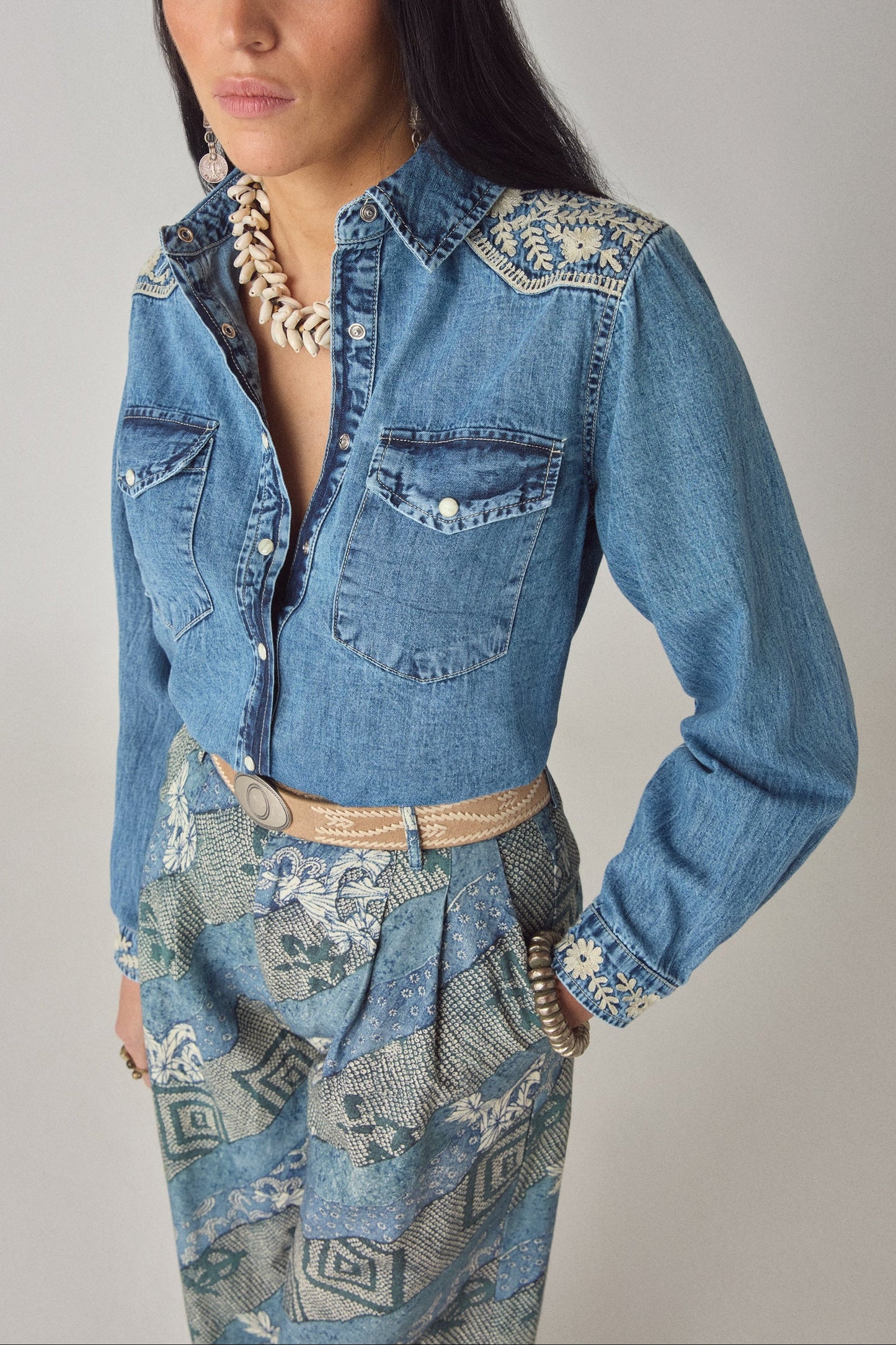 Close-up front detail of the Arizona Thelma denim shirt featuring floral embroidery on the shoulders and chest flap pockets