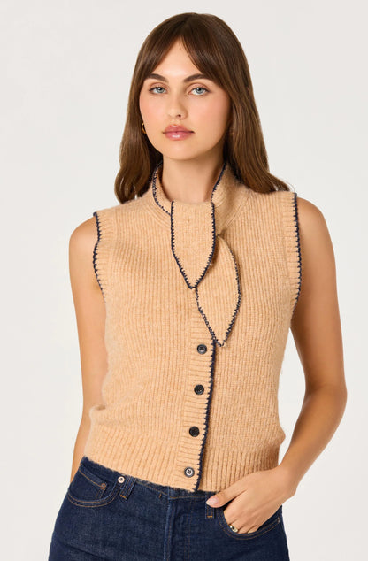Model wearing the Auberthe Sweater Vest in beige ribbed knit with navy contrast trim, button-front closure, and cropped fit.
