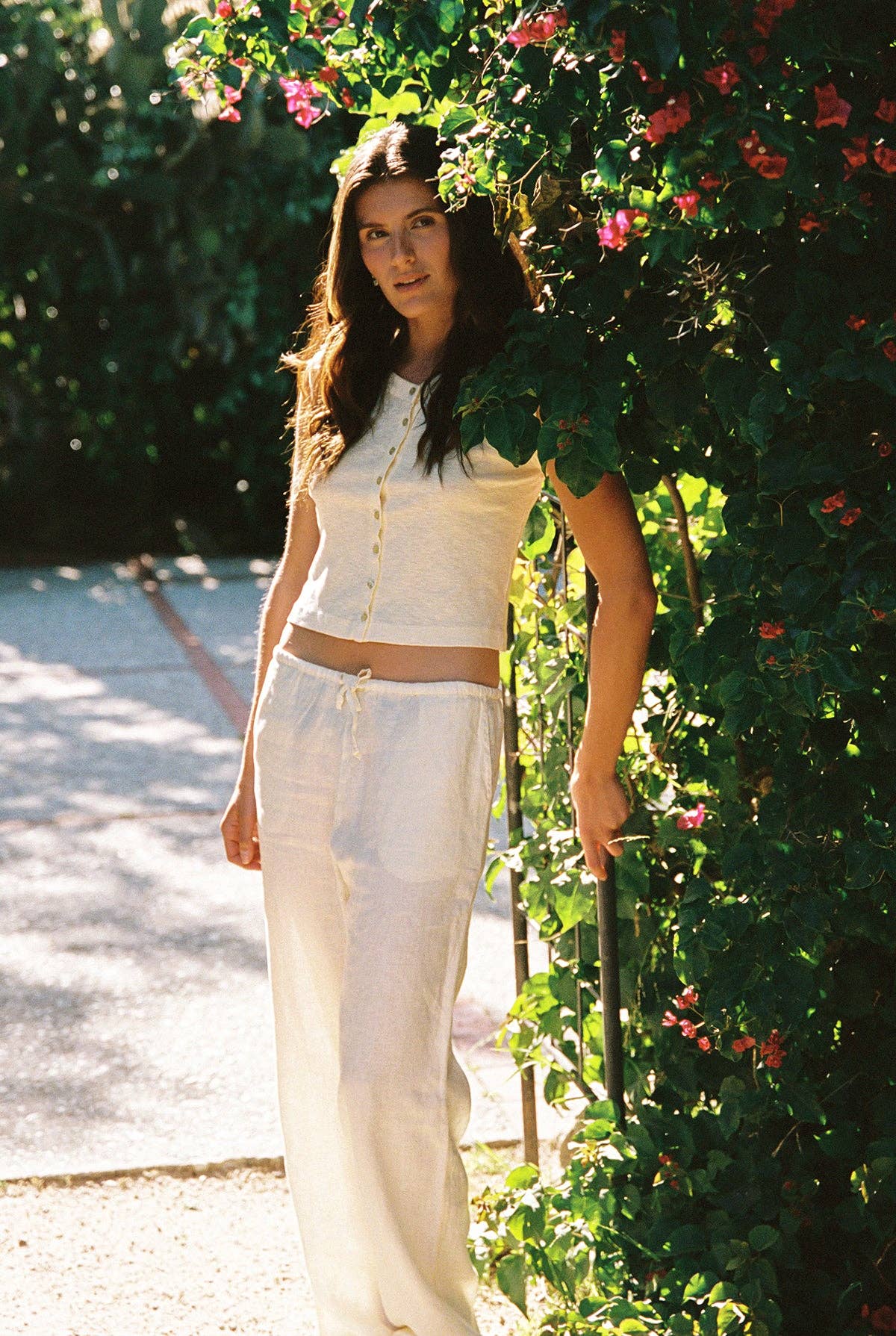 Model wearing the Auguste Slub Top in Butter styled with cream drawstring pants outdoors in natural sunlight.