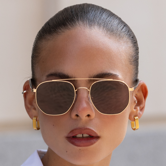 Model wearing the Austin Unisex Sunglasses in gold with brown lenses for an easy everyday look.