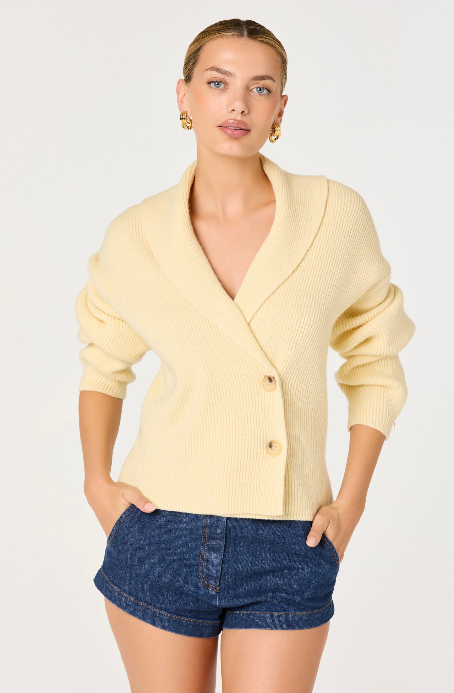Model wearing the Ayleen Ribbed Wrap Cardigan in Butter Yellow with a wrap V-neckline, button-front closure, and cropped fit.