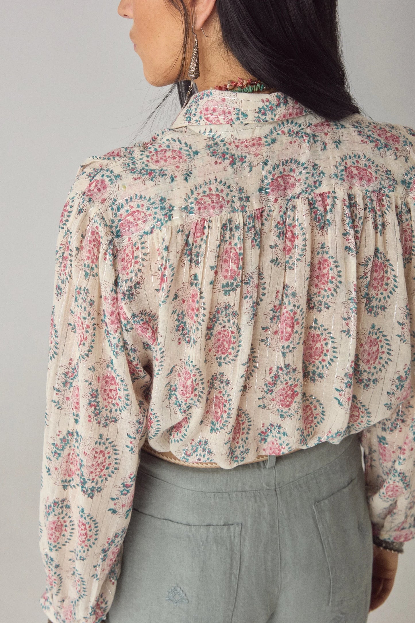 Back detail of the Azalea Mary blouse showing gathered fabric, long sleeves, and floral paisley print on a cream lurex gauze base.