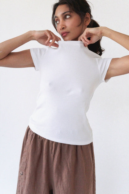 Model wearing the Bebe Organic Teen Tee in White with a soft fitted silhouette and cap sleeves.