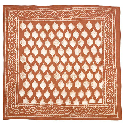 Square burnt orange cotton bandana featuring a hand block printed tile grid motif with an ivory geometric border. Crafted from lightweight, ultra-soft cotton using traditional block printing techniques and eco-friendly dyes.