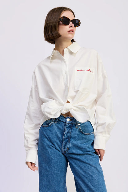 Model styling the Brittany Oversized Shirt tied at the waist with blue denim jeans and sunglasses