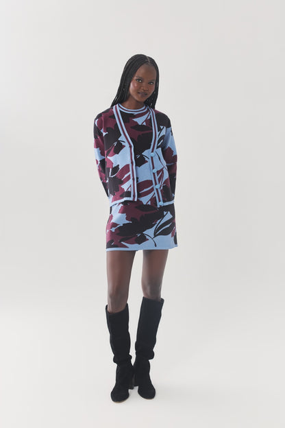 Model walking in the Brook Cardigan and matching floral knit mini dress with knee-high boots.