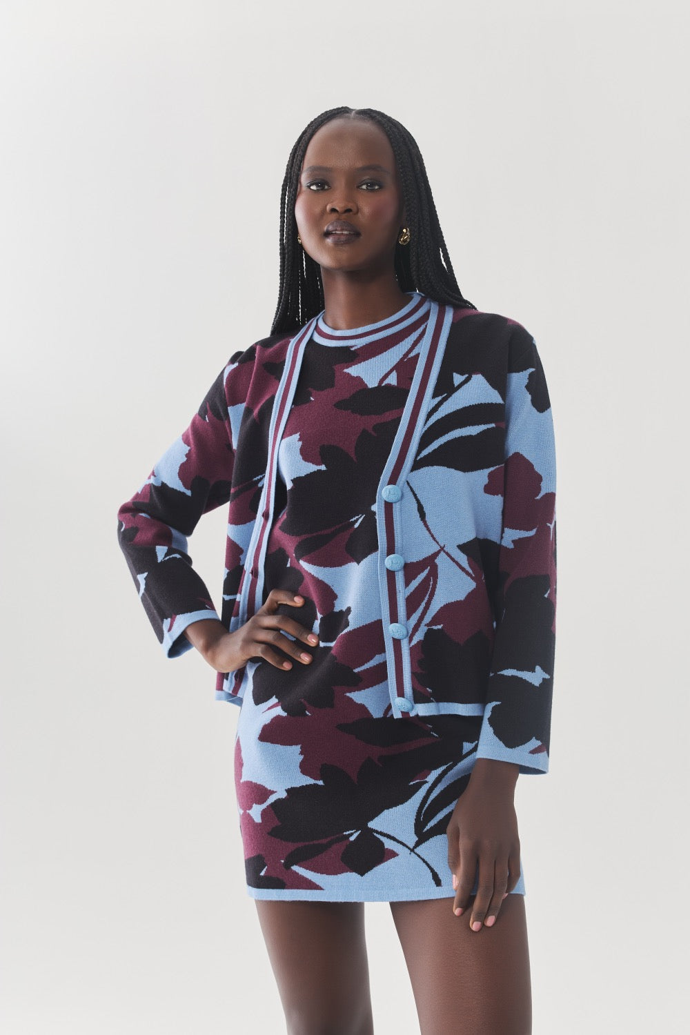 Model wearing the Brook Cardigan with the coordinating three-tone floral knit dress and black knee-high boots.