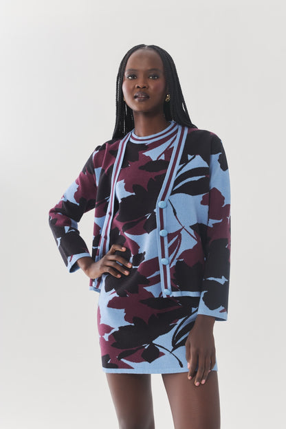 Model wearing the Brook Cardigan with the coordinating three-tone floral knit dress and black knee-high boots.