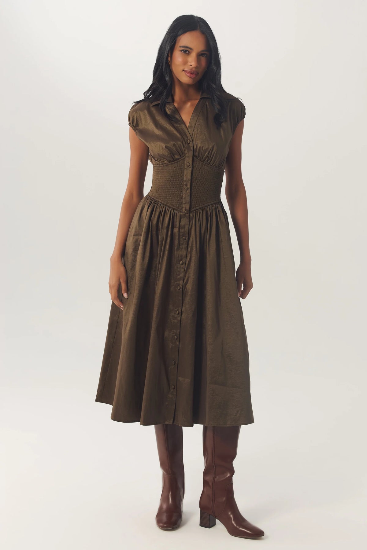 Model wearing the Brynny Dress in Olive featuring a fitted bodice, defined waist, and full midi skirt.