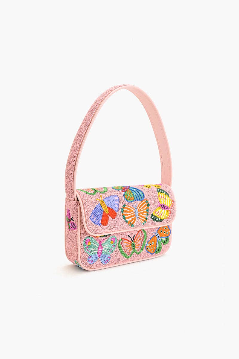 Angled view of the Butterfly Garden Beaded Shoulder Bag showing its structured shape, butterfly beadwork, and light pink shoulder strap.