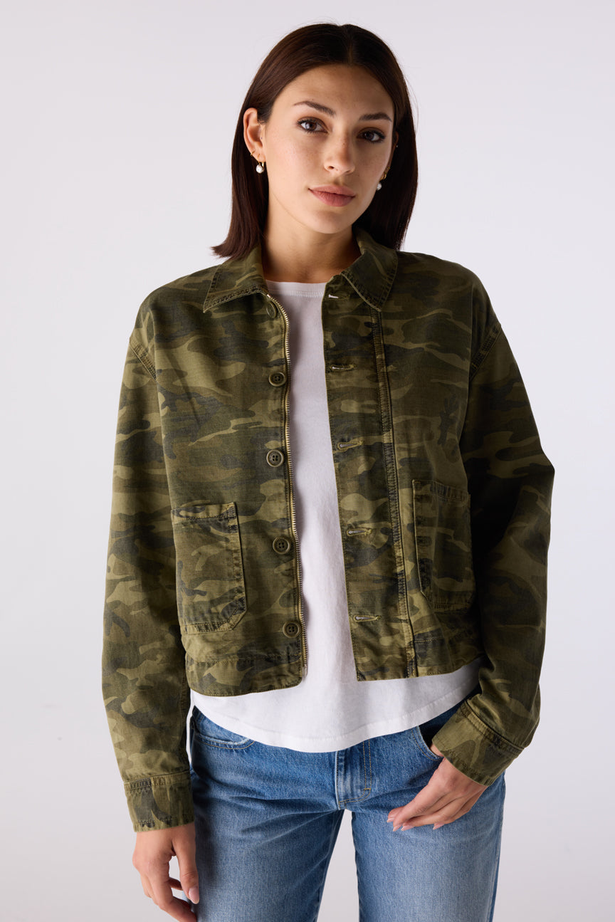Woman wearing the Little Rowdy Cadet Jacket in camo with front button closure and patch pockets