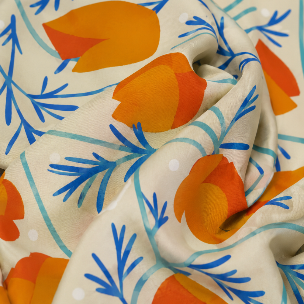 Close-up of the California Poppies silk scarf fabric, highlighting the smooth drape and colorful floral illustration.