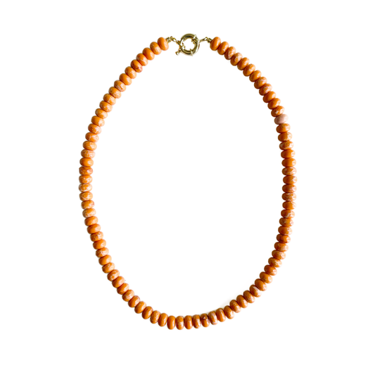 Orange jasper gemstone bead necklace with an 18kt gold plated clasp on a white background.