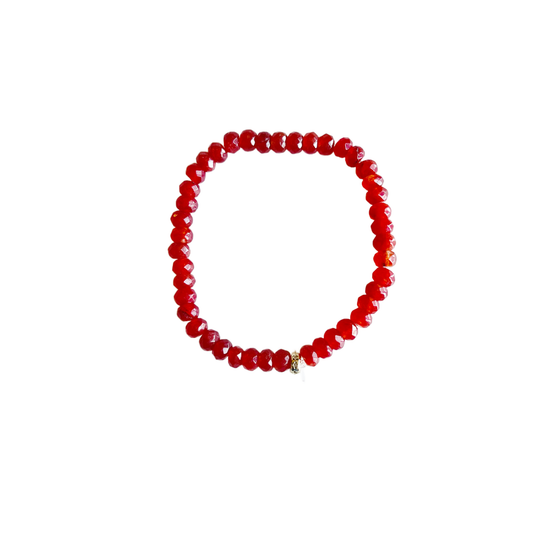 Red jade stretch bracelet with faceted beads and a pavé spacer bead on a white background.